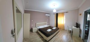 TepelenëにあるVealのベッドとテレビのある寝室