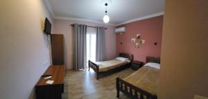 TepelenëにあるVealのベッド2台とソファ1台とテーブル1台がある部屋