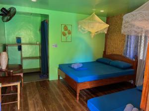 Habitación con cama, mesa y silla en Faith Tourist Inn, en San Vicente