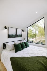 a bedroom with a large white bed with three windows at The Alto in Logan