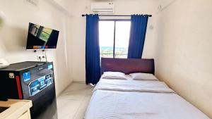 mała sypialnia z łóżkiem i oknem w obiekcie Apartement Skyhouse Bsd TL26K By LiviRooms Tangerang w mieście Samporo