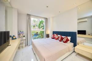 a bedroom with a large bed with red pillows at Pattaya Jomtien Apartments l Guest Friendly l Waterpark Gym Sauna Jacuzzi in Pattaya South