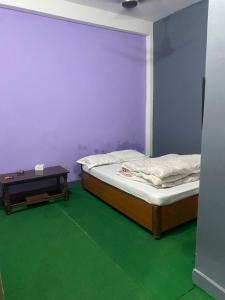 two twin beds in a room with a table at Hotel Bajhang in Bahāsi