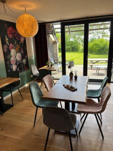 a dining room with a table and chairs at B&B Terpboerderij Jannum in Janum