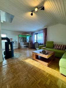 ein Wohnzimmer mit einem grünen Sofa und einem Couchtisch in der Unterkunft Family & Friends Retreat in Wiesbaum