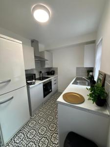 a white kitchen with a sink and a refrigerator at Spacious 3-Bedroom Apartment with Modern Comforts in Runcorn