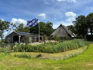 a british flag flying in front of a house at B&B Terpboerderij Jannum in Janum