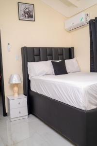 a bedroom with a black and white bed and a nightstand at Dowayne 1bed 1 bath in gated community colbeck manor in Old Harbour