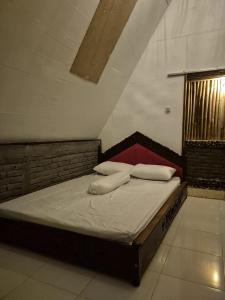 a bed with two pillows on it in a room at Zalfa Homestay in Taliwang