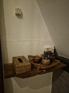 a shelf with pots and pans on a wall at Zalfa Homestay in Taliwang