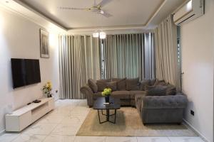 een woonkamer met een bank en een tv bij Villa Alpaca in Accra