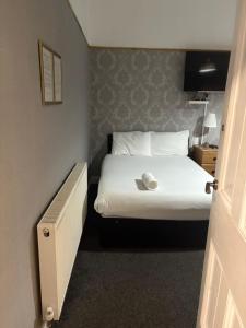Una habitación de hotel con una cama con un colchón blanco. en Segreto Inn, en Glasgow