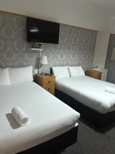 una habitación de hotel con dos camas y un televisor de pantalla plana en Segreto Inn, en Glasgow