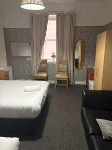 una habitación de hotel con una cama y un sofá en Segreto Inn, en Glasgow