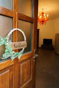 una porta in legno con un cartello di benvenuto di Elegant apartment near the Sacra- La Casita di Sopra a Caprie