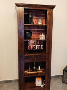 una libreria in legno con un caffettiere sopra di Elegant apartment near the Sacra- La Casita di Sopra a Caprie Altre 8 foto
