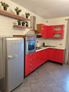 una cucina con mobili rossi e un frigorifero di Elegant apartment near the Sacra- La Casita di Sopra a Caprie