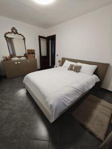 una camera da letto con un grande letto bianco e uno specchio di Elegant apartment near the Sacra- La Casita di Sopra a Caprie