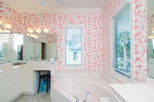 een badkamer met een bad en roze behang bij Alvarez II in Edisto Island +37 foto's