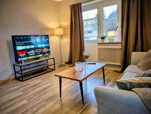 a living room with a television and a coffee table at Cosy & modern 3-sleeps apartment near Katrineholm Centre in Katrineholm