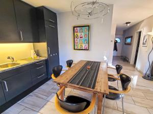 a kitchen with a wooden table and black cabinets at Apartment Collina Verde B by Interhome in Ascona