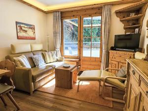 a living room with a couch and a tv at Apartment Chesa Alvetern 5 by Interhome in Sils Maria +11 photos