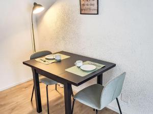 洛伊克巴德Apartment Ringstrasse - Utoring-3 by Interhome的一张桌子,上面有两把椅子和两个杯子