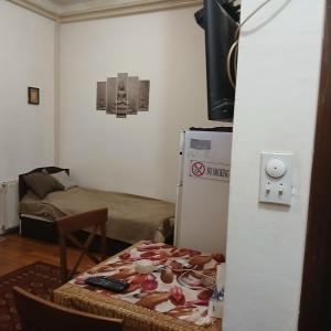 a small room with a table and a refrigerator at Tali in Novi Sad