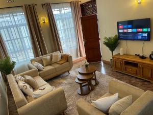 a living room with couches and a flat screen tv at Famurest in Nkoanrua