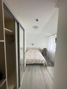 een witte slaapkamer met een bed en een raam bij Sn family in Radekhov