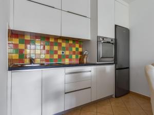 eine Küche mit weißen Schränken und einem Edelstahlkühlschrank in der Unterkunft Apartment Anica-1 by Interhome in Zadar
