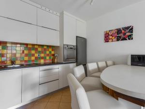eine Küche mit weißen Schränken und einem weißen Tisch in der Unterkunft Apartment Anica-1 by Interhome in Zadar