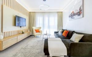 a living room with a couch and a tv at Kalm apartment- Luxury Living with a Gym, Heated Pool & Stunning Views in Nairobi