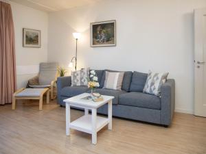 a living room with a blue couch and a table at Apartment Helene Apt-Diana by Interhome in Wengen