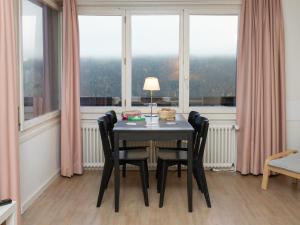 a table with chairs and a lamp in a room with windows at Apartment Helene Apt-Diana by Interhome in Wengen +37 photos