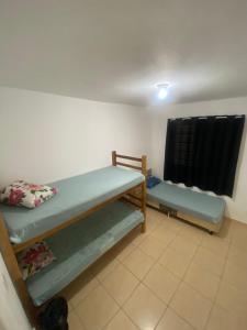 una stanza con due letti a castello e una finestra di Paraíso Montanha e Mar a Peruíbe