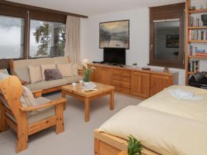 a living room with two beds a couch and a tv at Apartment Primula Apt- B by Interhome in Wengen +26 photos