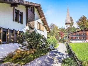 a house with a pathway next to a church at Apartment Primula Apt- B by Interhome in Wengen