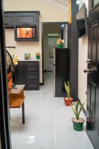 a kitchen with black cabinets and a refrigerator at Dowayne 1bed 1 bath in gated community colbeck manor in Old Harbour