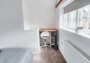 a bedroom with a desk and a chair next to a window at Cosy & Luxury 2BR Flat in Calverton in Calverton