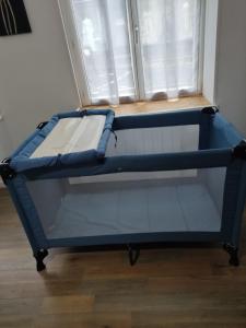 una cama azul en una habitación con ventana en Bienvenue chez Coco, en Dunkerque