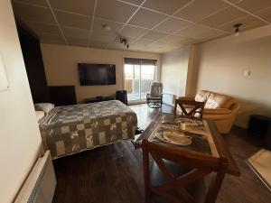 a bedroom with a bed and a table and a couch at Logement tout inclus Baie Comeau in Baie-Comeau