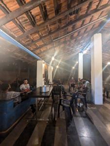a group of people sitting at a table in a restaurant at Aangan by Gokarma Living in Gokarna