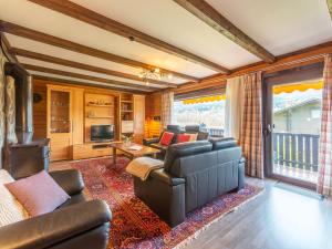 a living room with a leather couch and a fireplace at Apartment Am Hohen Bogen-64 by Interhome in Kummersdorf