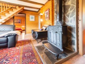 a living room with a fireplace in a log cabin at Apartment Am Hohen Bogen-64 by Interhome in Kummersdorf