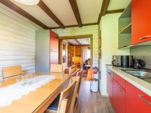 a kitchen with red cabinets and a wooden table at Apartment Am Hohen Bogen-64 by Interhome in Kummersdorf