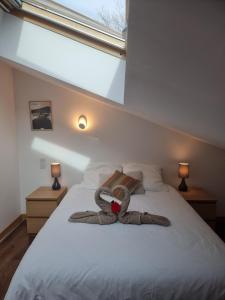 un ours en peluche farci posé sur un lit dans une chambre dans l'établissement MALIBAIX, à Aix-les-Bains