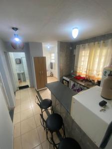 una cucina con frigorifero bianco e alcune sedie di Paraíso Montanha e Mar a Peruíbe