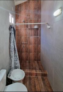 ein Badezimmer mit Dusche, Toilette und Waschbecken in der Unterkunft Apart Altos de Monte Hermoso in Monte Hermoso + 5 Fotos