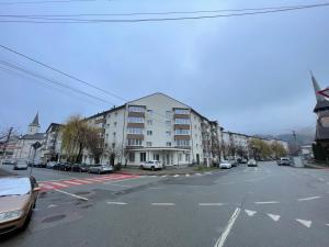 Una calle vacía con coches aparcados al costado de un edificio. en Izvor apartament, en Borsa